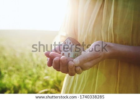 Hands holding model of house as symbol