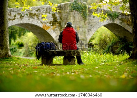 
Senior man hiking with bridge in background