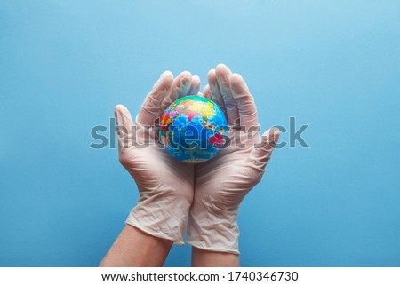 doctor's hands in medical surgical gloves holding earth globe on blue background, world health day and global health care concept Royalty-Free Stock Photo #1740346730