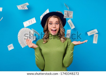 Photo of crazy lady hold fan dollar bucks rich freelance salary successful business woman catch money falling from sky wear specs hat green turtleneck isolated blue color background