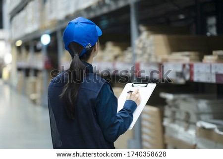 Warehouse worker checking inventory with clipboard in logistics warehouse Royalty-Free Stock Photo #1740358628