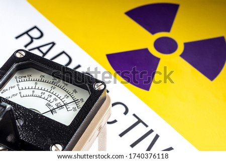 Hand-held radiation survey instrument detecting at the radioactive material symbol on label Royalty-Free Stock Photo #1740376118