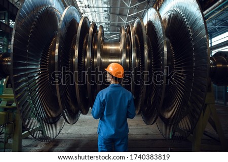 Worker checks turbine impeller vanes on factory Royalty-Free Stock Photo #1740383819