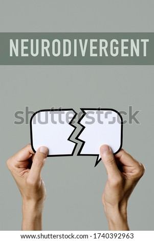 closeup of a young caucasian man holding a broken speech balloon in his hands and the text neurodivergent on a gray background Royalty-Free Stock Photo #1740392963