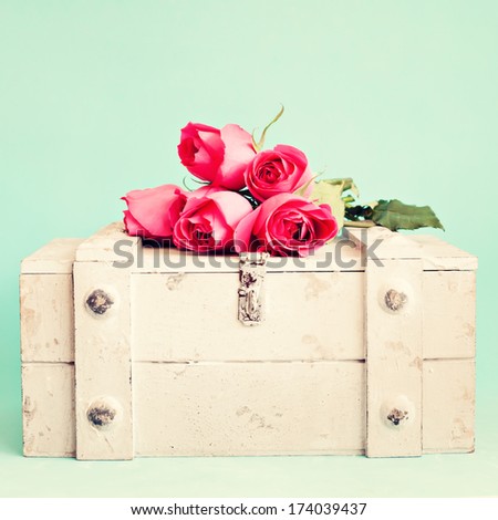 Vintage still life with roses over a chest 