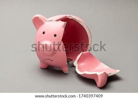 Broken piggy bank on gray background. Royalty-Free Stock Photo #1740397409