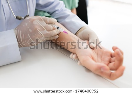 Asian doctor or nurse hands with syringe injecting to wrist medical. Wrist bone problems painful wrist caused by prolonged work. Carpal tunnel syndrome, arthritis, neurological disease concept. 