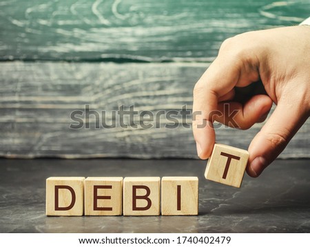 Businessman puts wooden blocks with the word Debit. Fundraising, company profit. Debit account. Business and finance concept. Accounting company.