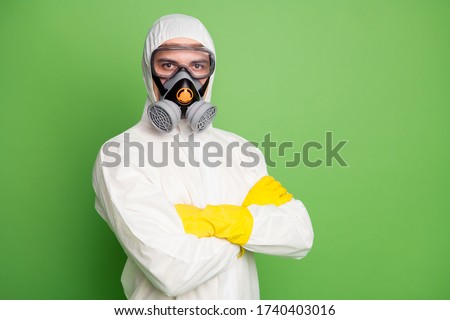Close-up portrait of his he nice content serious professional disinfectant wearing gas mask anti viral pollution radiation quarantine folded arms isolated over green pastel color background Royalty-Free Stock Photo #1740403016