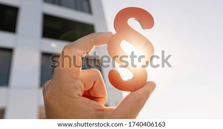 Hand holds paragraph symbol in the sky, law and justice Concept image