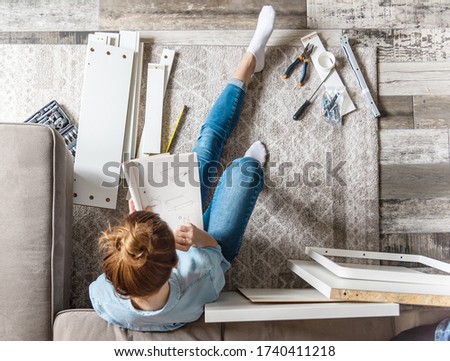 Concentrated young woman reading the instructions to assemble furniture at home in the living room
 Royalty-Free Stock Photo #1740411218