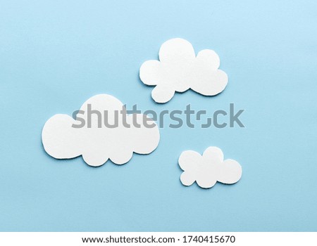 white clouds on blue sky background made of colored paper