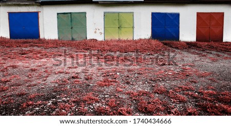 Old garage block with an infrared meadow in front