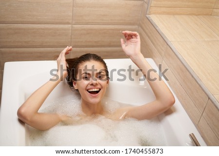 Happy woman in the bathroom laughing with hands up
