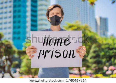 Man in medical mask prevents coronavirus disease holds a poster home prison Hand written text - lettering isolated on white. Coronovirus COVID 19 concept