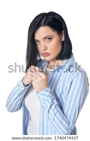 Portrait of aggressive young woman showing fists isolated on white background