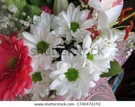 Holiday flowers. A beautiful bouquet of white chrysanthemums, pink roses and delicate gerberas in a paper wrapper 