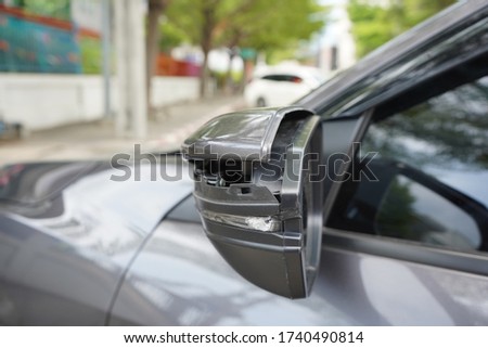 Rearview mirror has broken from car accident. Side view damage. Grey color car damaged and broken by accident on road.