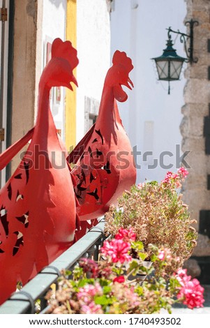 red decorative metal roosters in óbidos, portugal