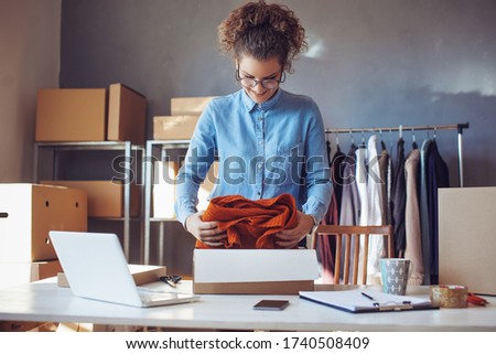Small business owner. Women, owner of small business packing product in boxes preparing it for delivery. Royalty-Free Stock Photo #1740508409