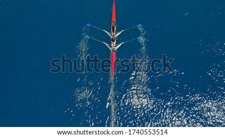 Aerial drone photo of women athletes exercising sport canoe in open ocean deep blue sea