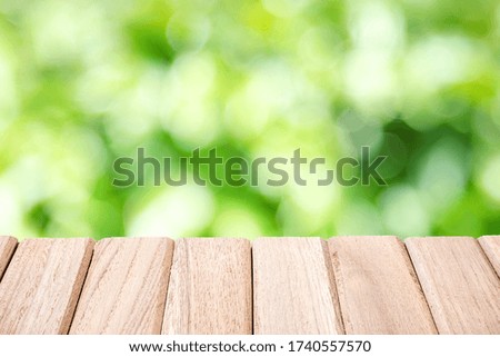The surface of the wooden table isolated on Green light abstract blur bokeh of leaves for home decoration And gardening decoration