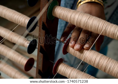 A Handloom Weaver preparing yarns  in India. Royalty-Free Stock Photo #1740571238