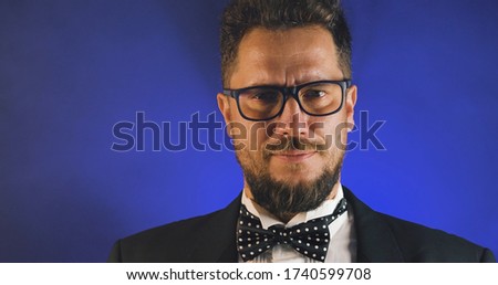 Handsome man in suit  on black background. Portrait of elegance gentleman with glasses. Luxury lifestyle. Portrait of adult spy wearing trendy suit in studio. 