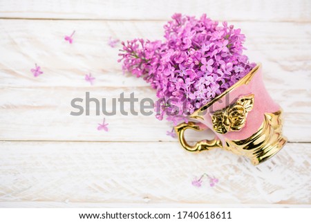 pink and gold cup with lilac  purple flower 