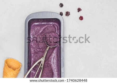 Easy homemade blackberry ice cream with banana and avocado on neutral background with space for text, above view