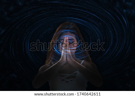 Young woman meditation by folding hands together connect to universe energy , mind and body healing. Royalty-Free Stock Photo #1740642611