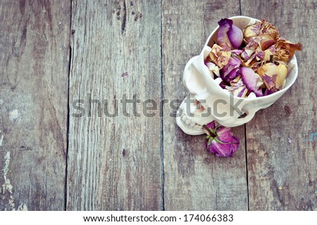 skull with the faded roses on a wooden table