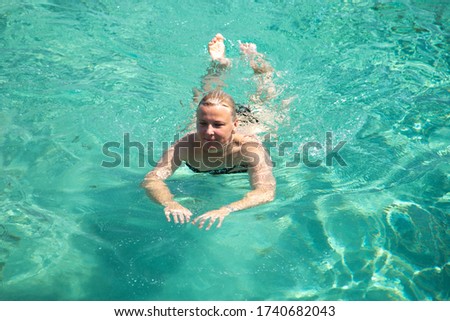 Woman swimming in blue sea water on the beach