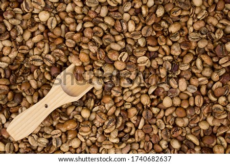 Background of middle coffee beans  and wooden spoon