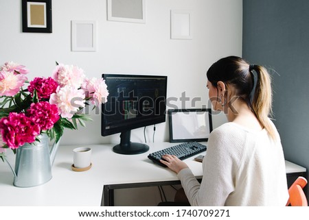 peonies in a garden watering can, a desktop in the home. woman at work