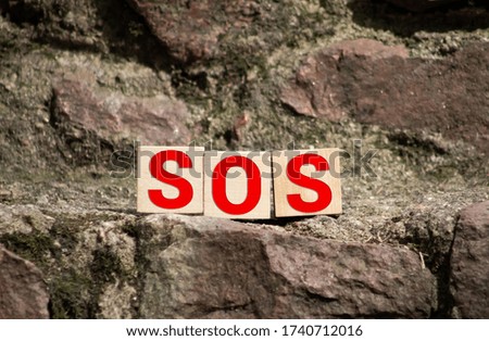 Wooden blocks forming the letters SOS isolated on white background