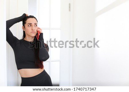 Girl conducts business negotiations by phone in a white interior