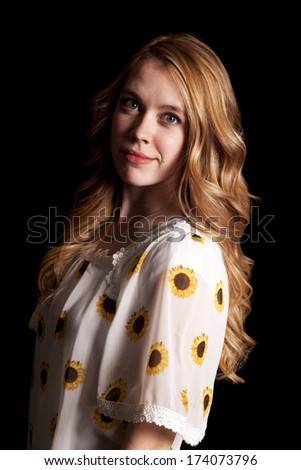 A woman in her sunflower shirt with a small smile on her lips.