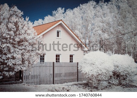 Infrared photography. Surreal landscape, a rustic house surrounded by trees with white foliage . Our beautiful world in the spectrum of infrared camera which we do not see with the usual eye.