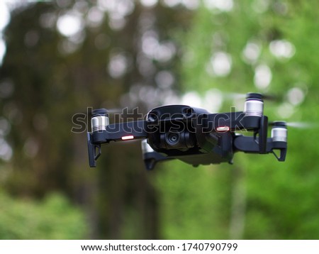 Unmanned drone flies against the background of the nature of the forest, a drone with a digital camera