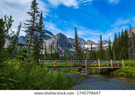 2589 Picturesque scene along the Grinnell Glacier Trail at Glacier National Park, Montana as a footbridge crosses a stream
