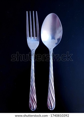 fork and spoon isolated on black background.