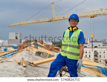 A construction site worker stands at the roof.Construction site worker 