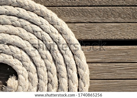 Concentric circles,  coils of a line on a wooden background, close detail view with space on one side.