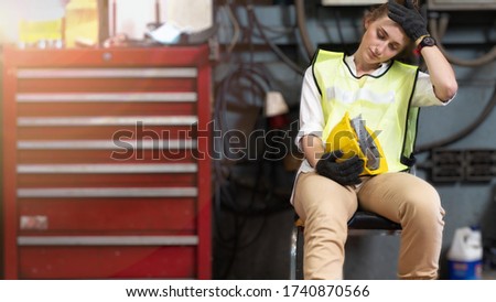 factory worker sitting on chair and suffering stress fail at factory workshop equipment. Royalty-Free Stock Photo #1740870566