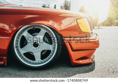 Tuned red sport car wheel, close up. Low rider sport auto. Royalty-Free Stock Photo #1740888749