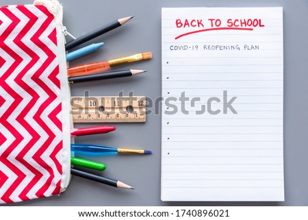 Back to school COVID-19 school reopening plan concept shot. Flay lay arrangement with school supplies Royalty-Free Stock Photo #1740896021