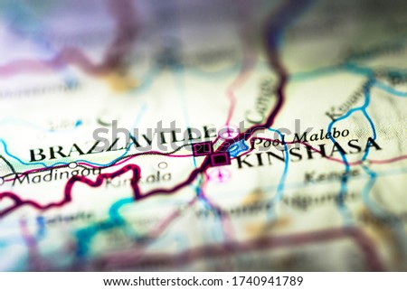 Shallow depth of field focus on geographical map location of Kinshasa Brazzaville twin city in Democratic Republic of the Congo Africa continent on atlas