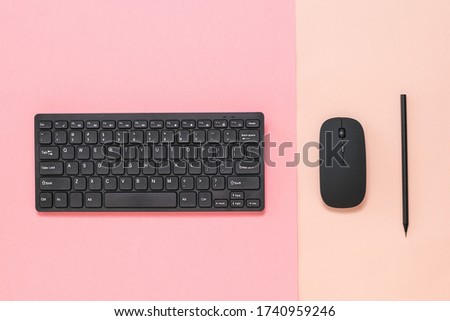 Black pencil, black mouse and keyboard on a two-color background. Peripheral devices for computers.