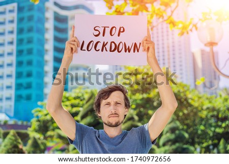 man holds a poster Stop lockdown. Hand written text - lettering isolated on white. Coronovirus COVID 19 concept
